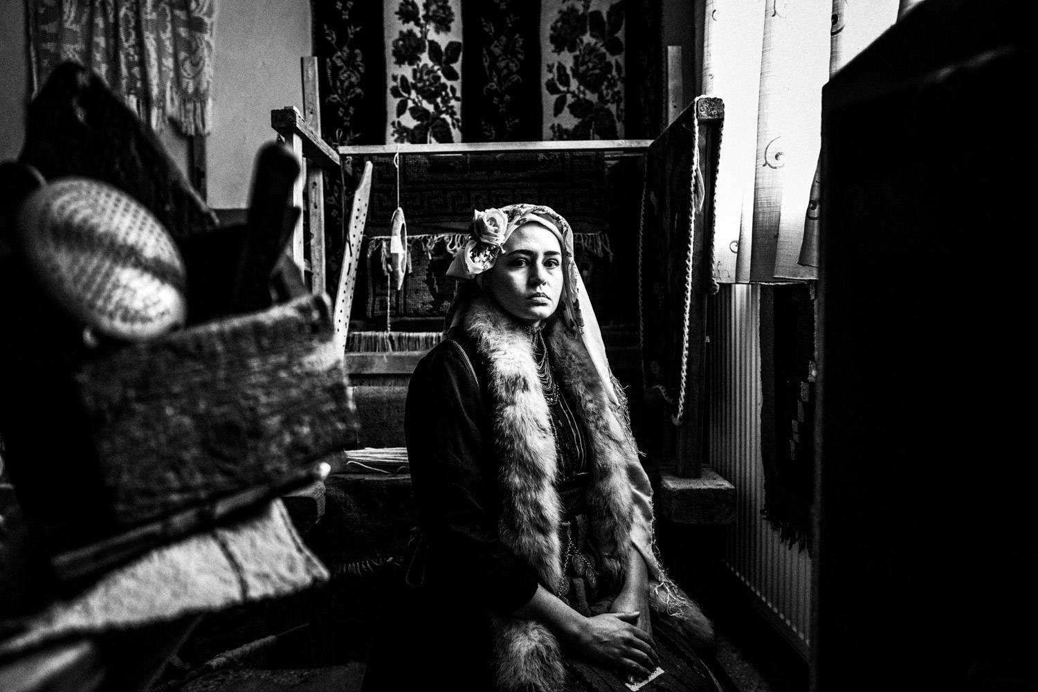 Sitting portrait of a woman in her traditional local costume. Skopos, Florina, Macedonia, Greece. Black and white photograph by George Tatakis