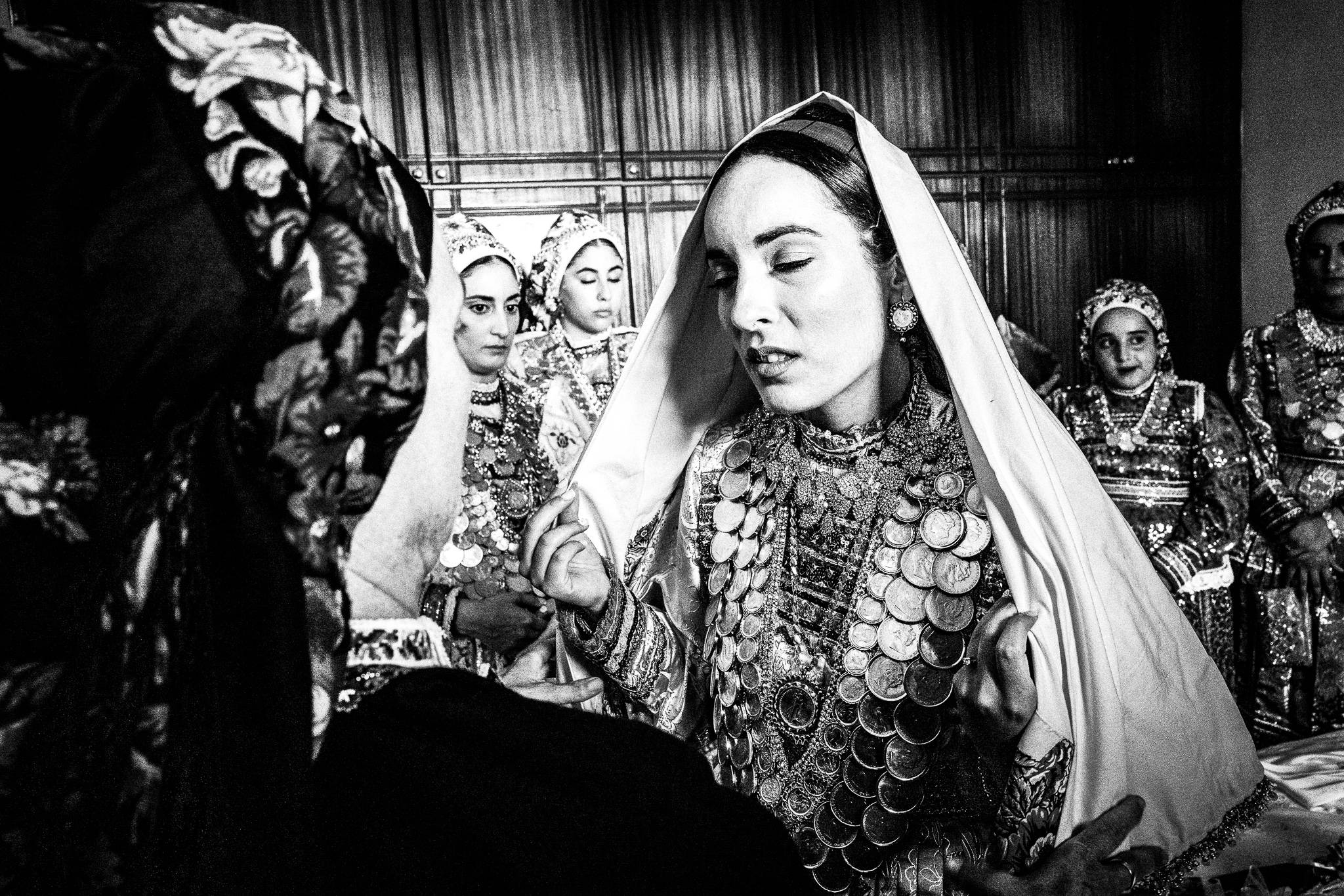Putting on the scarf at a traditional wedding at Olympos, Karpathos, Greece. Black and white photography by George Tatakis