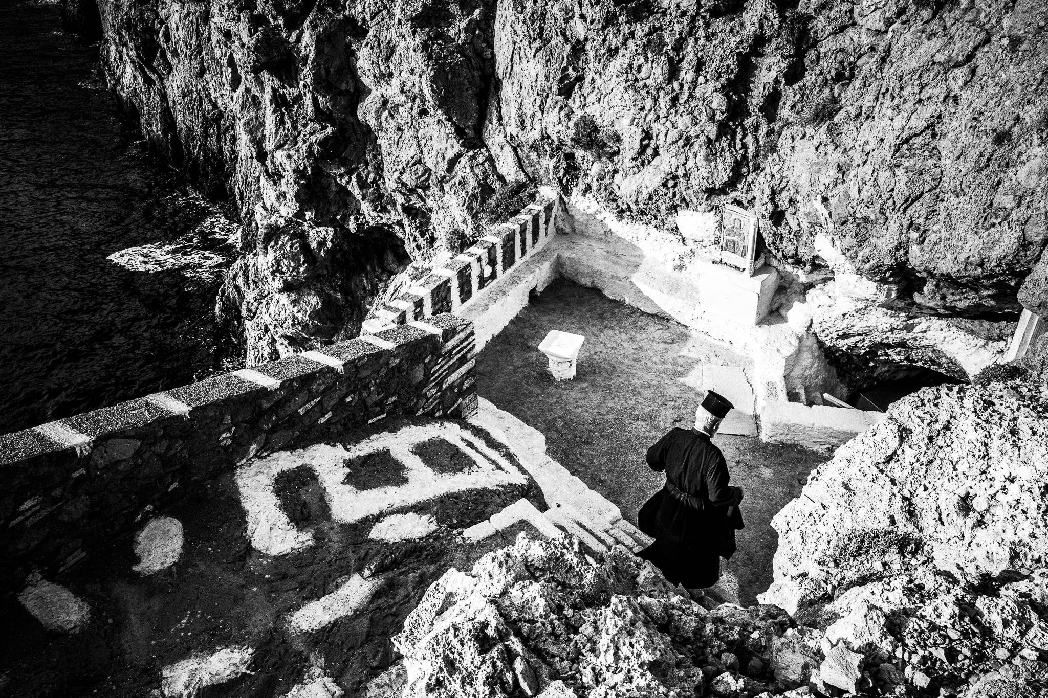 Going down to the cave church during the feast of Saint John at the site of the ancient city of Brykous, Olympos, Karpathos, Greece. Black and white photography by George Tatakis
