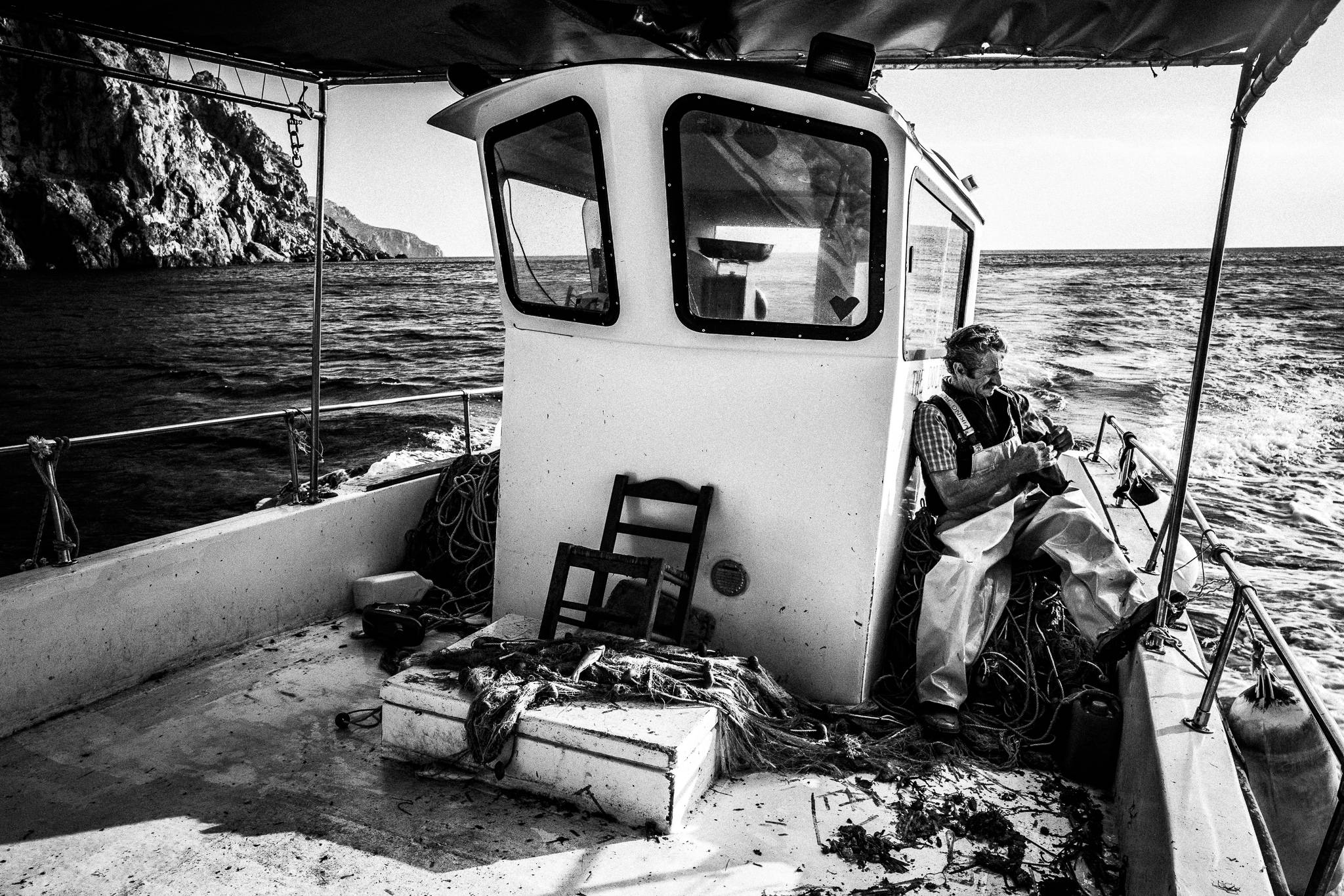 Yorgos picking fish, Diafani, Olympos, Karpathos, Greece. Black and white photography by George Tatakis