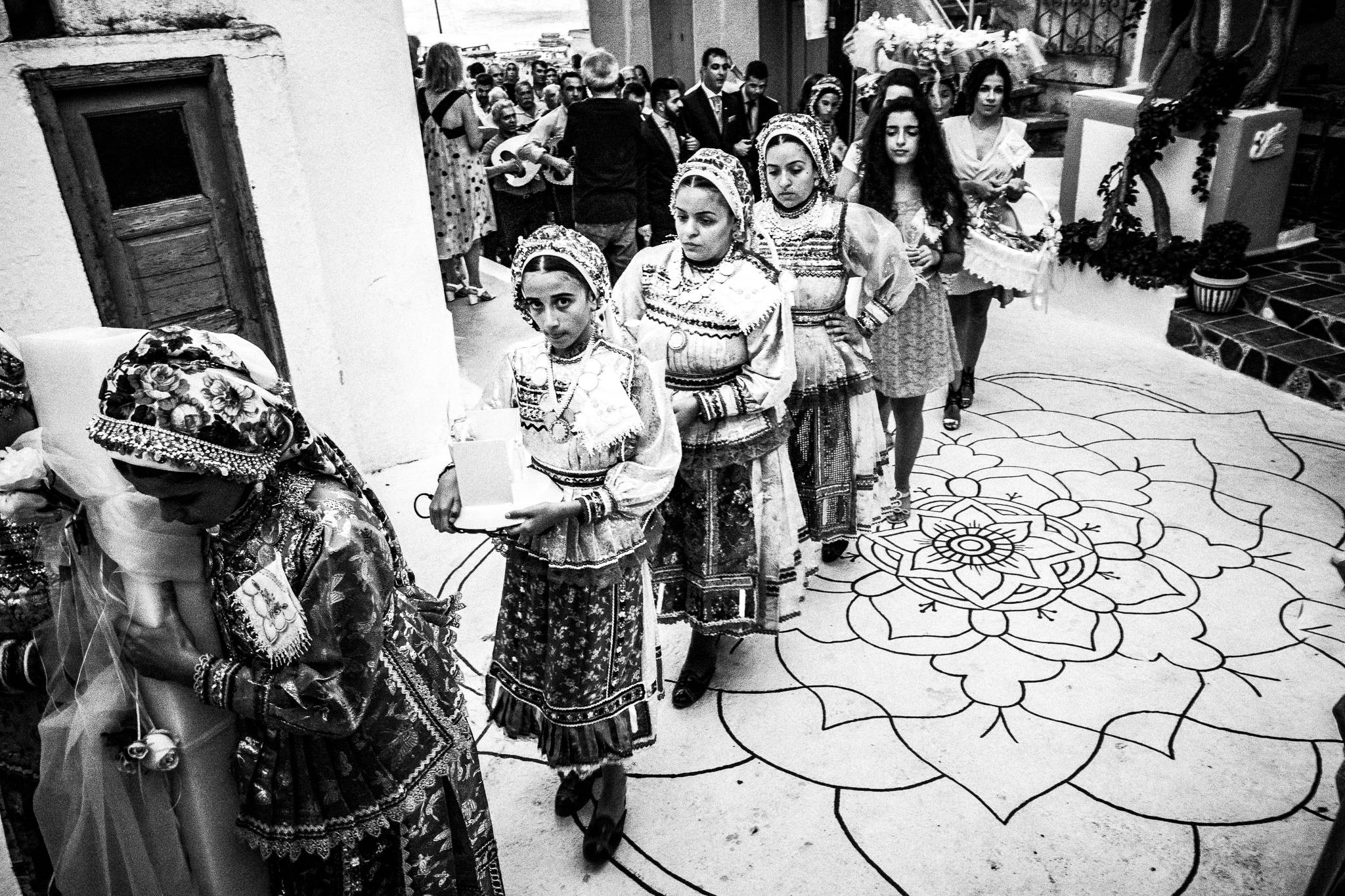 Escorting the groom to the church at Olympos, Karpathos, Greece. Black and white photography by George Tatakis