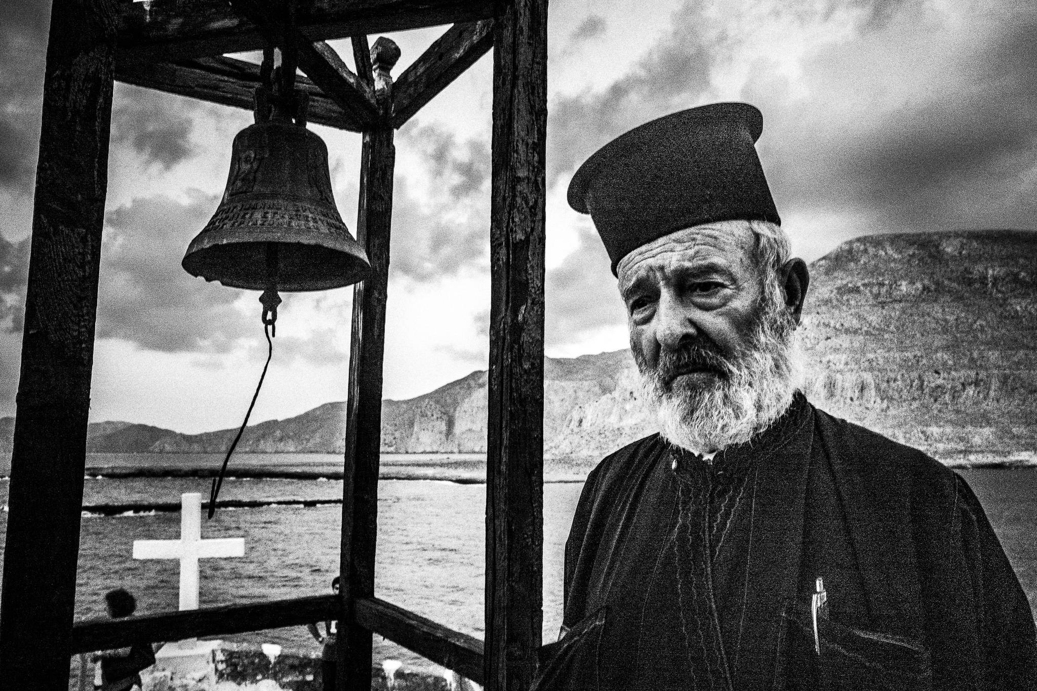 Striking the bell, during the feast of Saint John at the site of the ancient city of Brykous, Olympos, Karpathos, Greece. Black and white photograph by George Tatakis
