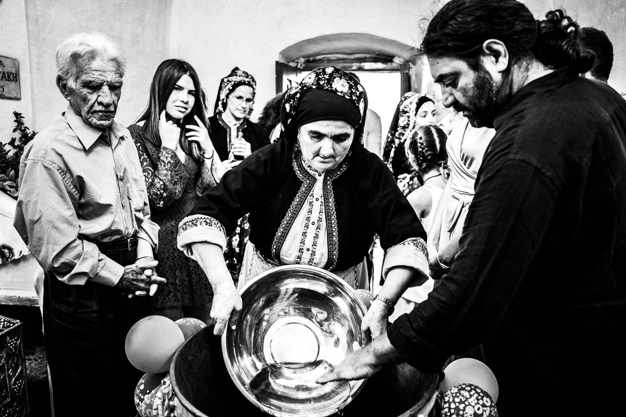 A traditional baptism in St. Minas, Olympos, Karpathos, Greece. Black and white photography by George Tatakis