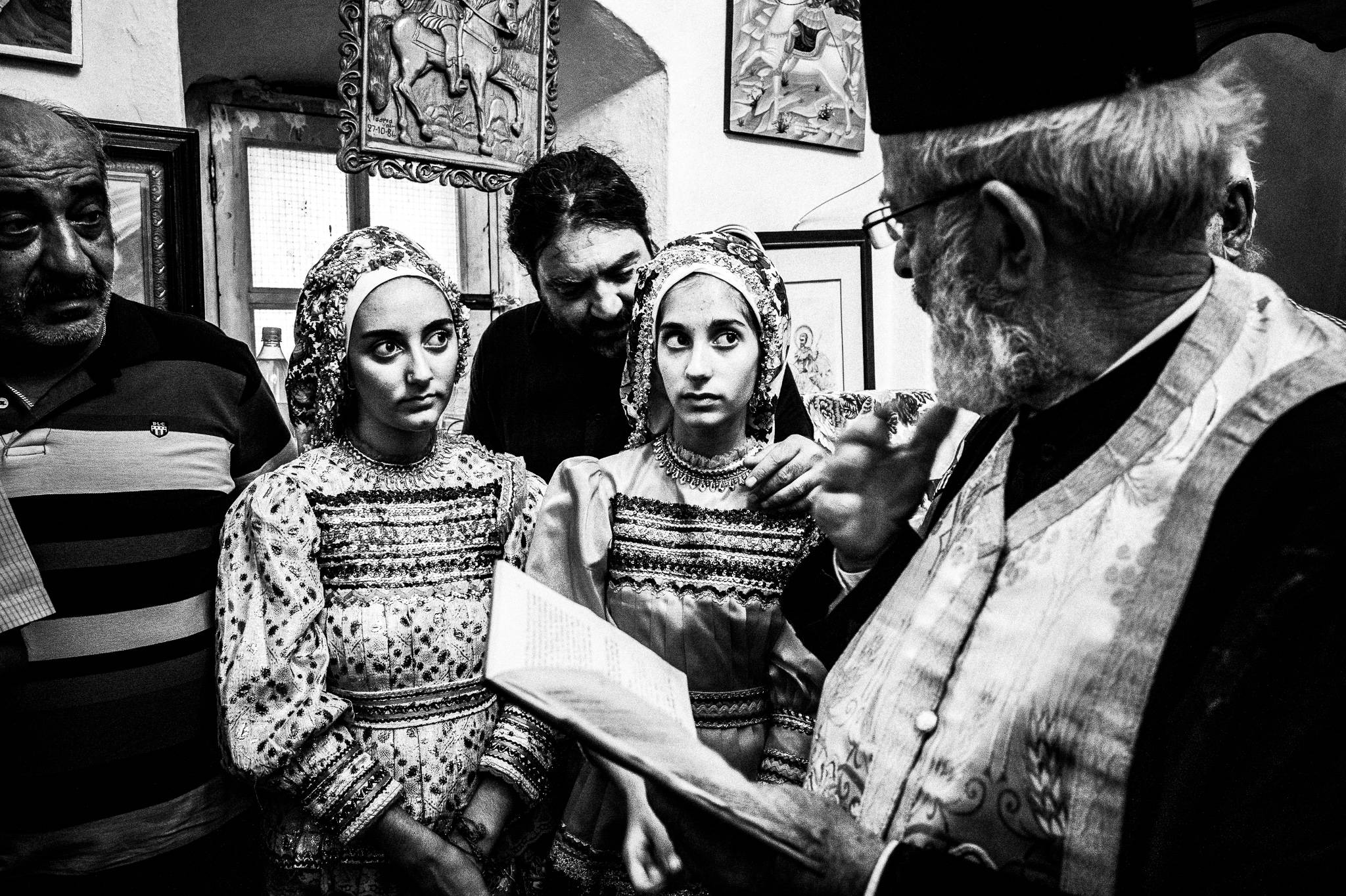 During a traditional baptism in St. Minas, Olympos, Karpathos, Greece. Black and white photography by George Tatakis