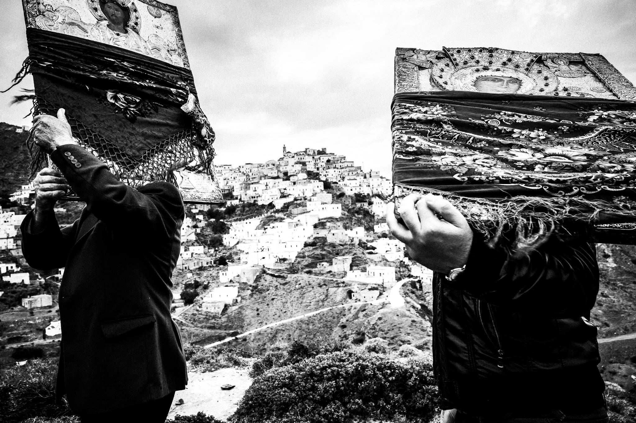 Two men carrying heavy Orthodox Icons, overlooking the village. Easter Tuesday. Olympos, Karpathos, Greece. 