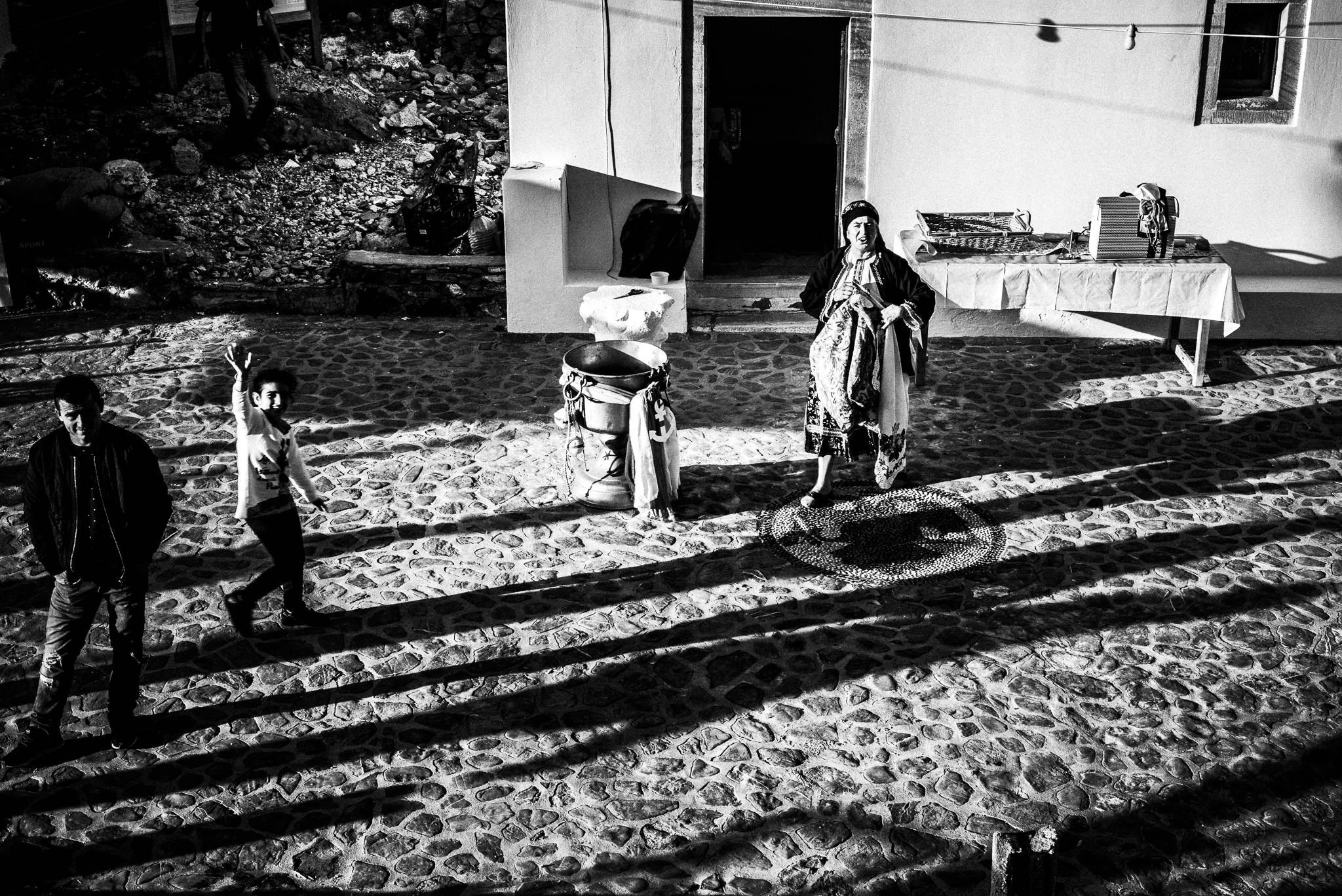 A warm welcome at the festival of Michael the Archangel at Tristomo, Olympos, Karpathos, Greece. Black and white photography by George Tatakis