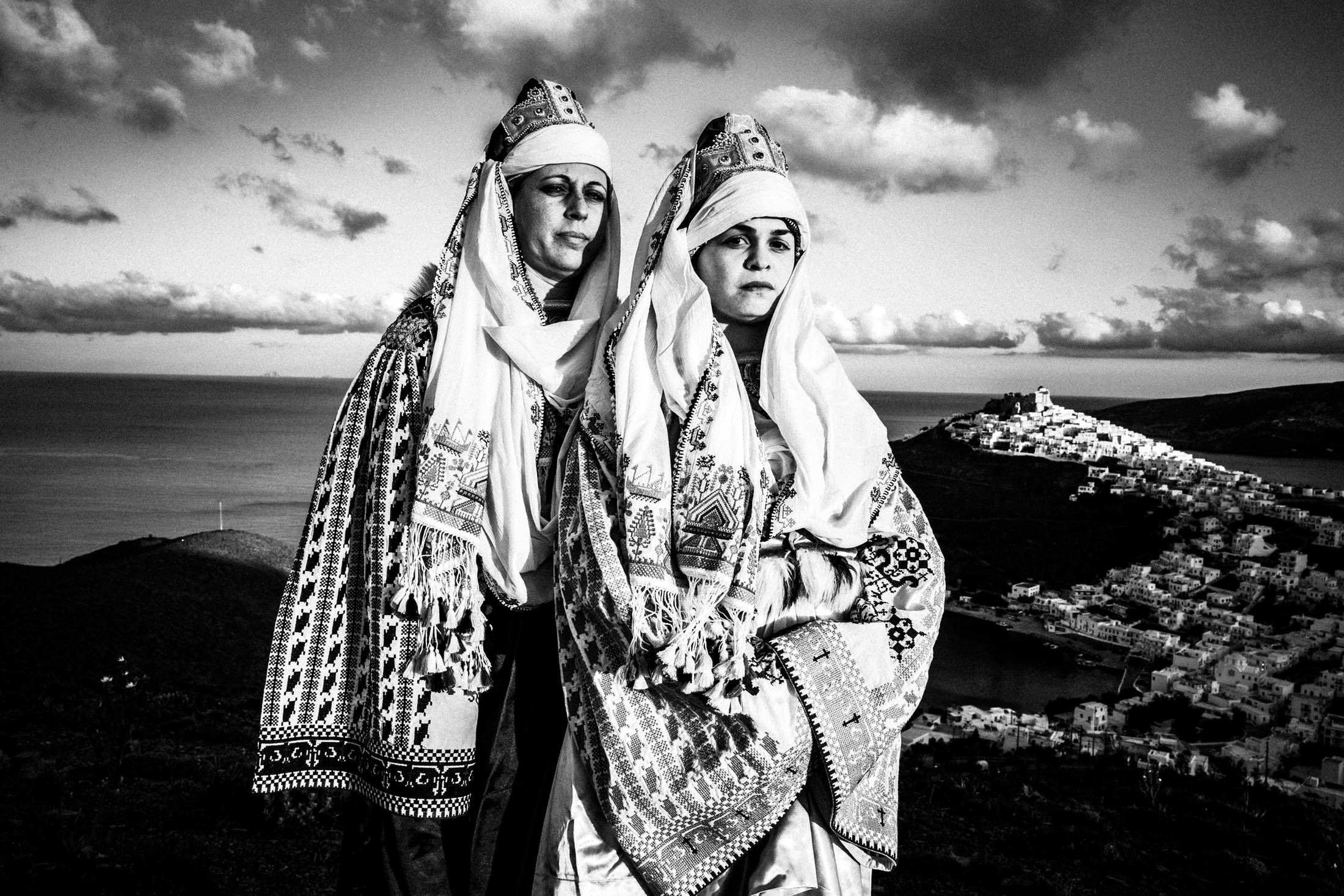 The ladies wearing the traditional costumes of Astypalaea, overlooking the town and the castle, by photographer George Tatakis