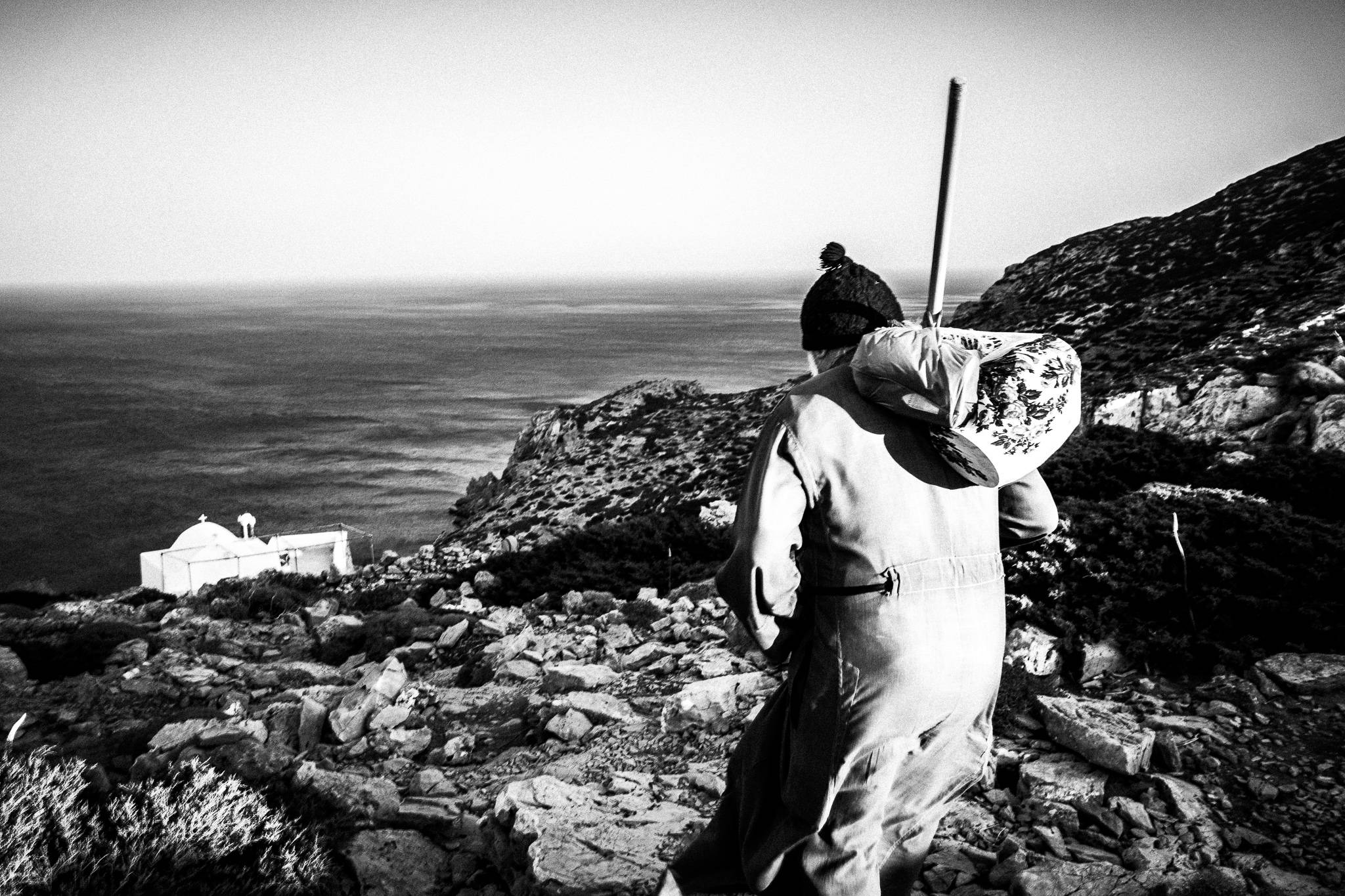 Reaching St. Zacharias' church on the island of Saria, Olympos, Karpathos, Greece. Black and white photography by George Tatakis