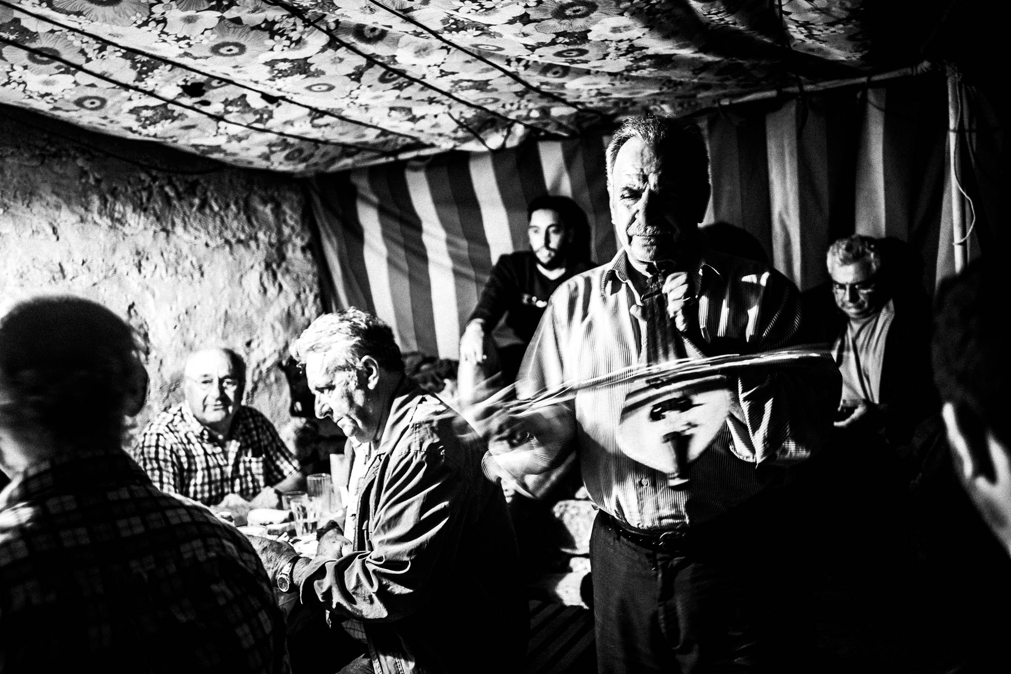 Playing the lyra at the festival of St. Zacharias at Argos on the island of Saria, Olympos, Karpathos, Greece. Black and white photography by George Tatakis
