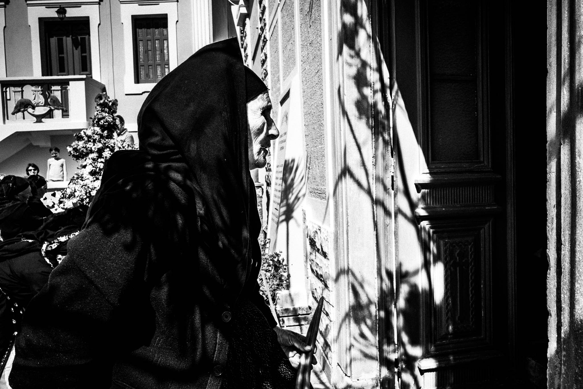 A woman in traditional black clothes, entering the main church. Olympos, Karpathos, Greece