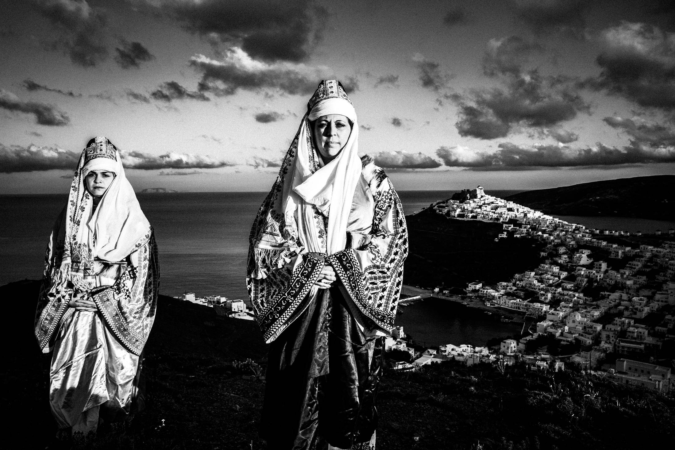 The ladies wearing the traditional costumes of Astypalaea, overlooking the town and the castle, by photographer George Tatakis