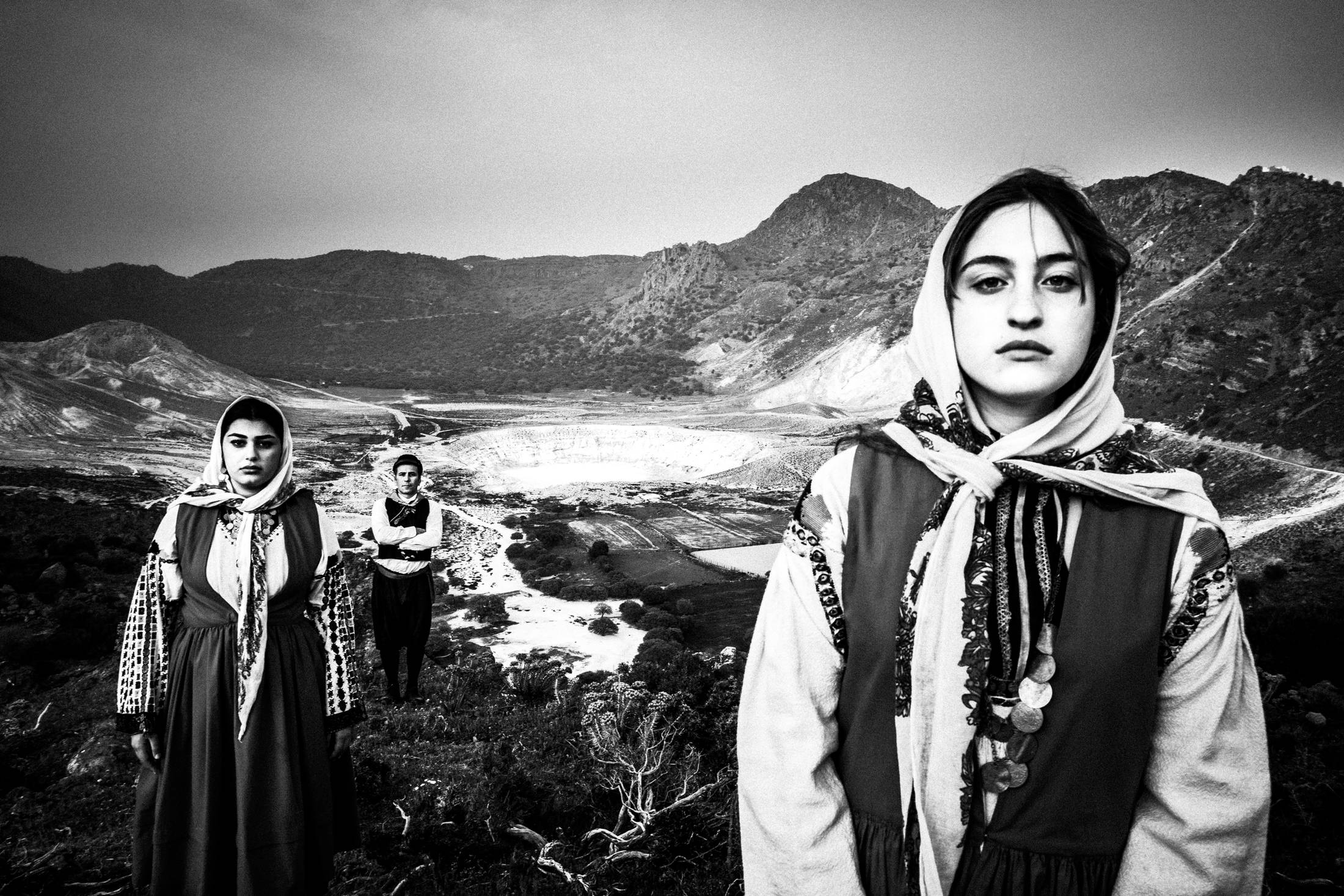 Traditional costumes, overlooking the volcanic vista, at Nisyros, Dodecanese, by photographer George Tatakis