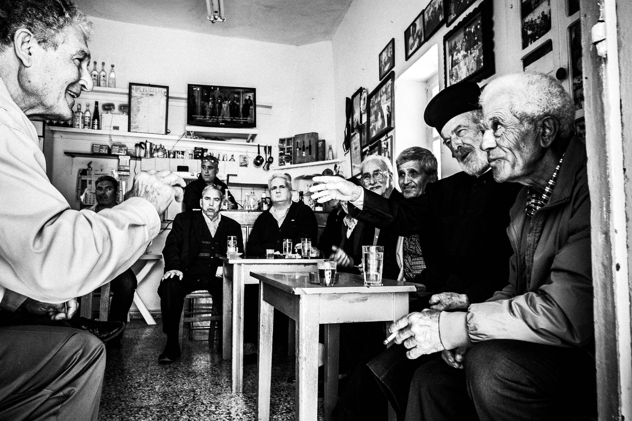 A group of men discussing at the central café of Olympos, on the island of Karpathos, Greece