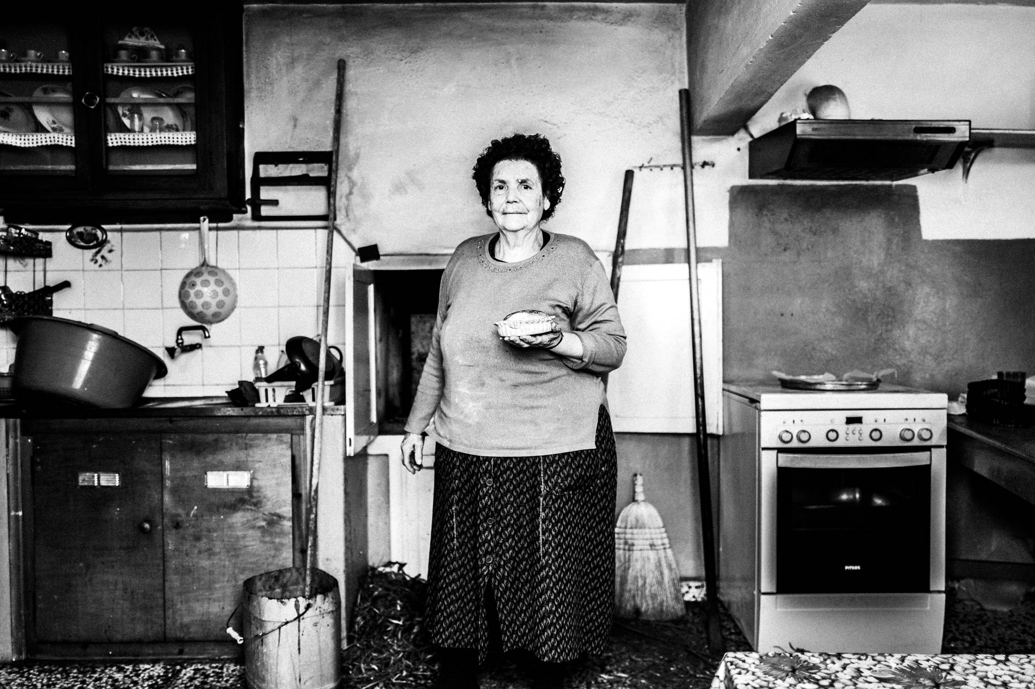 Moscha Gryllis, holding a freshly baked Patiniotiki pie in Patmos island, by photographer George Tatakis