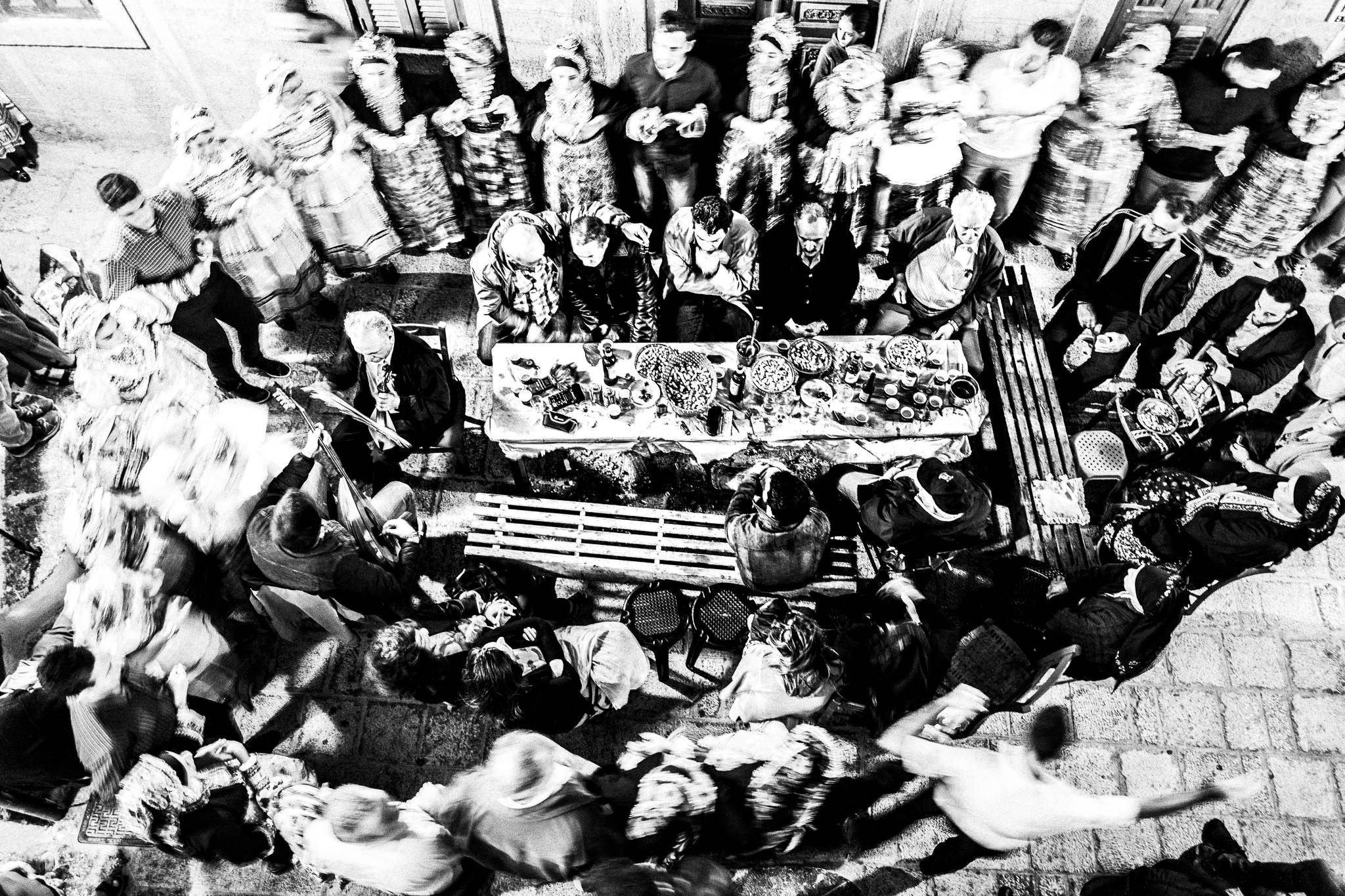 Dancing the ecstatic pano choros, around glentista’es at the central square of Olympos, Karpathos, Greece. Black and white photography by George Tatakis