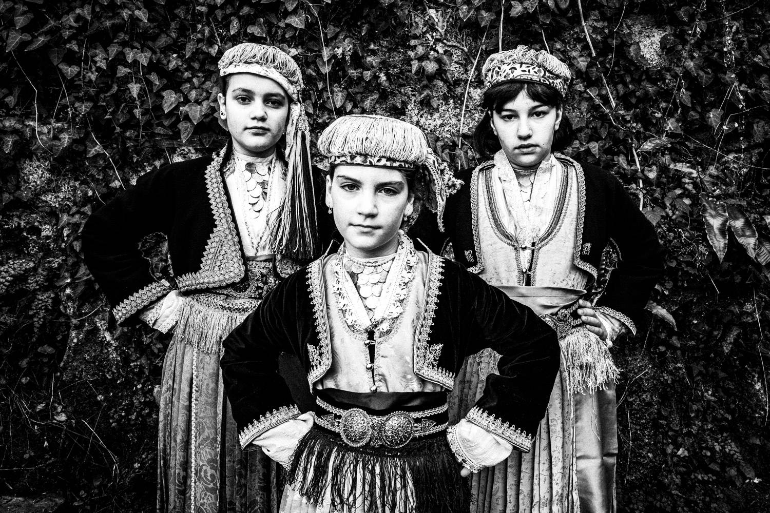 Three girls wearing the local folklore dresses of Naoussa, Imathia, Macedonia, Greece. Black and white photograph by George Tatakis