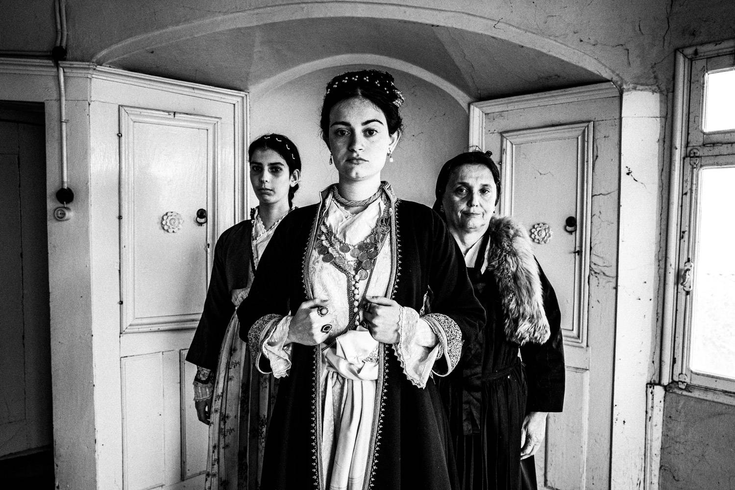 Three women wearing the urban folklore dresses of Veria, Macedonia, Greece. Black and white photograph by George Tatakis