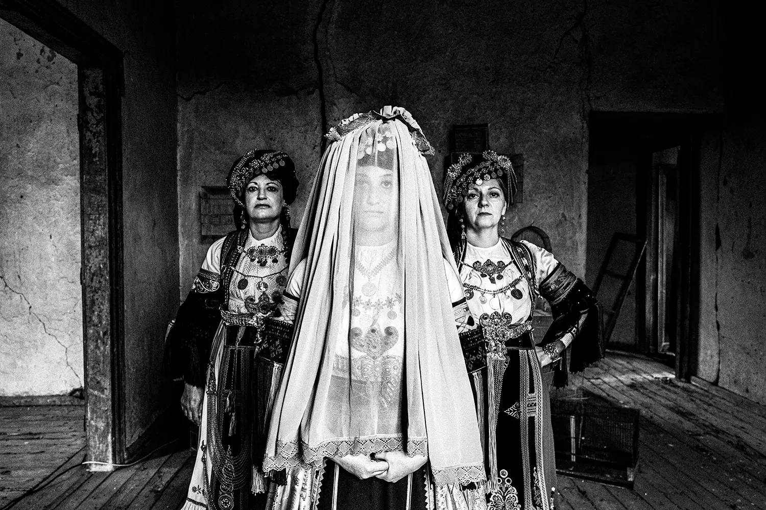 Three women including a bride, wearing the traditional Karagouna costumes of Trikala, Thessaly, Greece. Black and white photography by George Tatakis