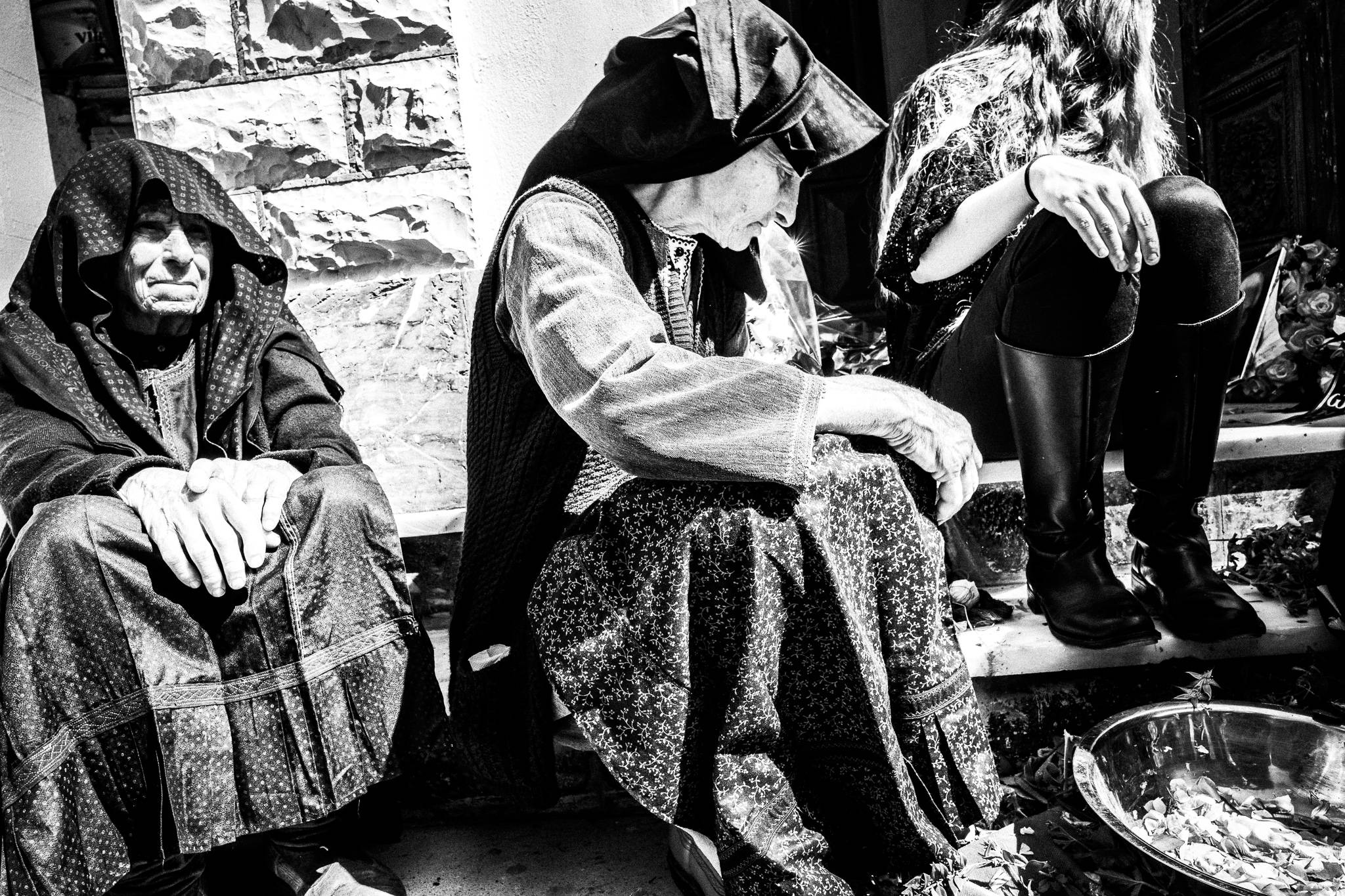 Three women sitting outside the main church. Olympos, Karpathos, Greece