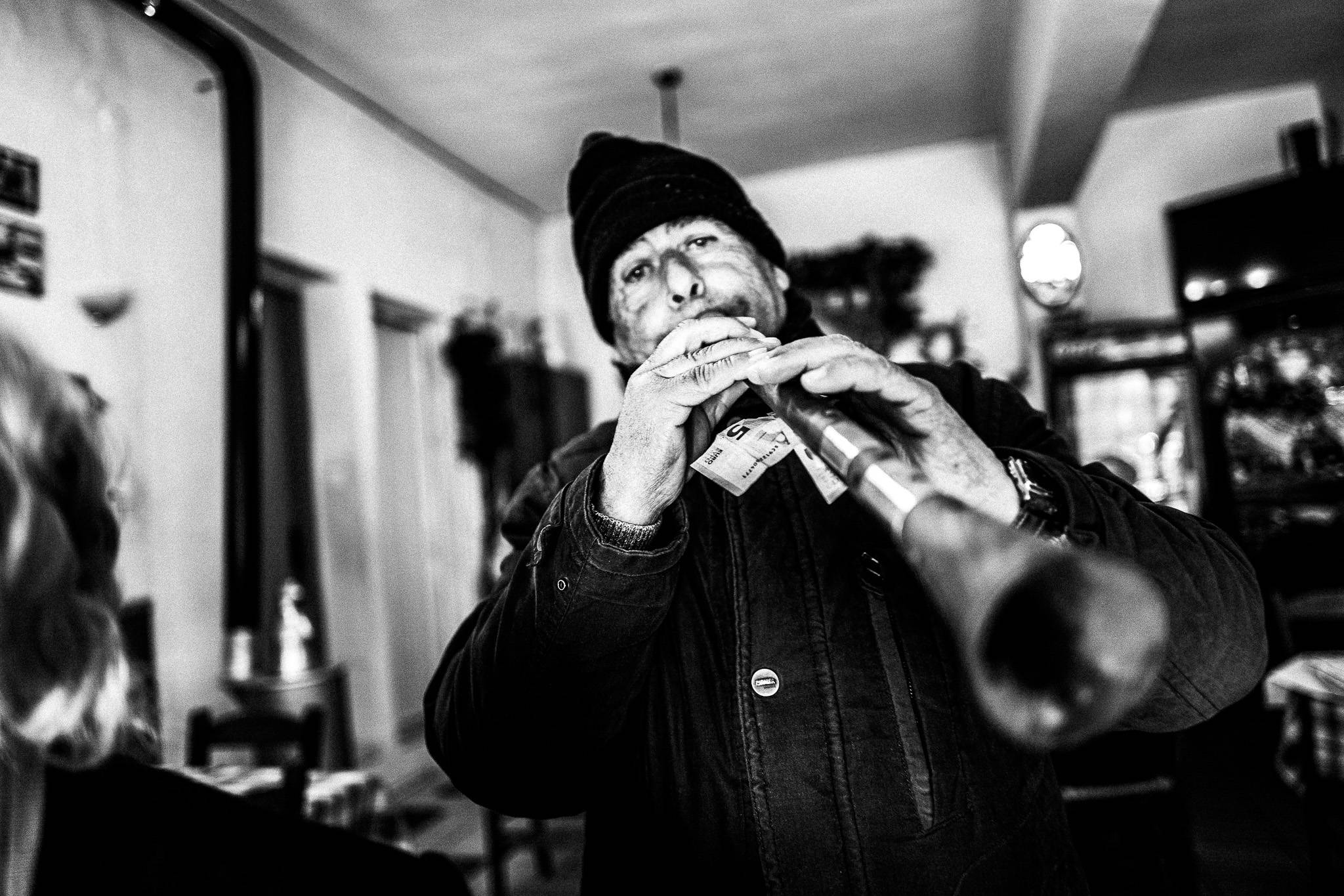 Musician at the café, Pagan Christmas customs of Northern Greece, by photographer George Tatakis