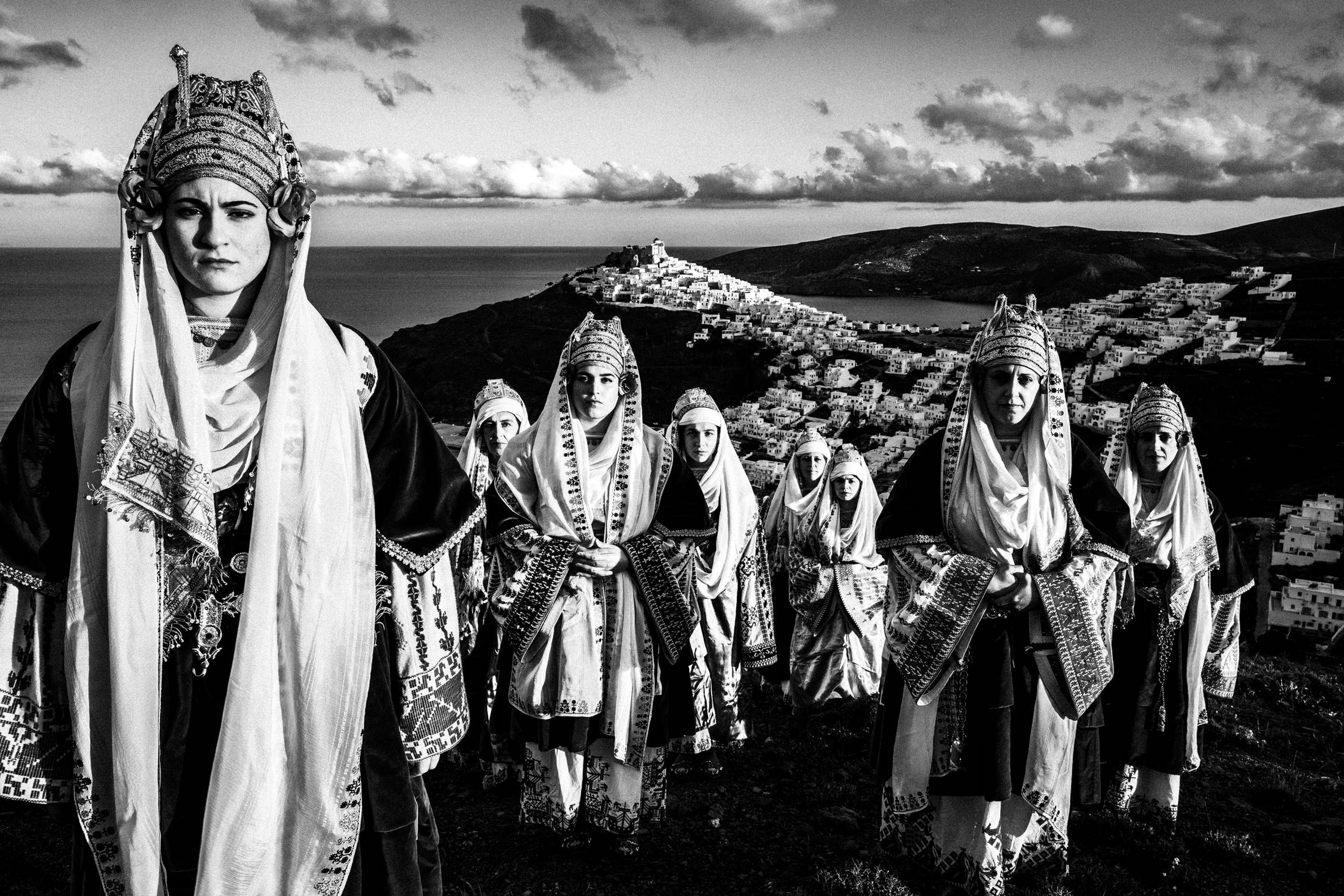 The ladies wearing the traditional costumes of Astypalaea, overlooking the town and the castle, by photographer George Tatakis