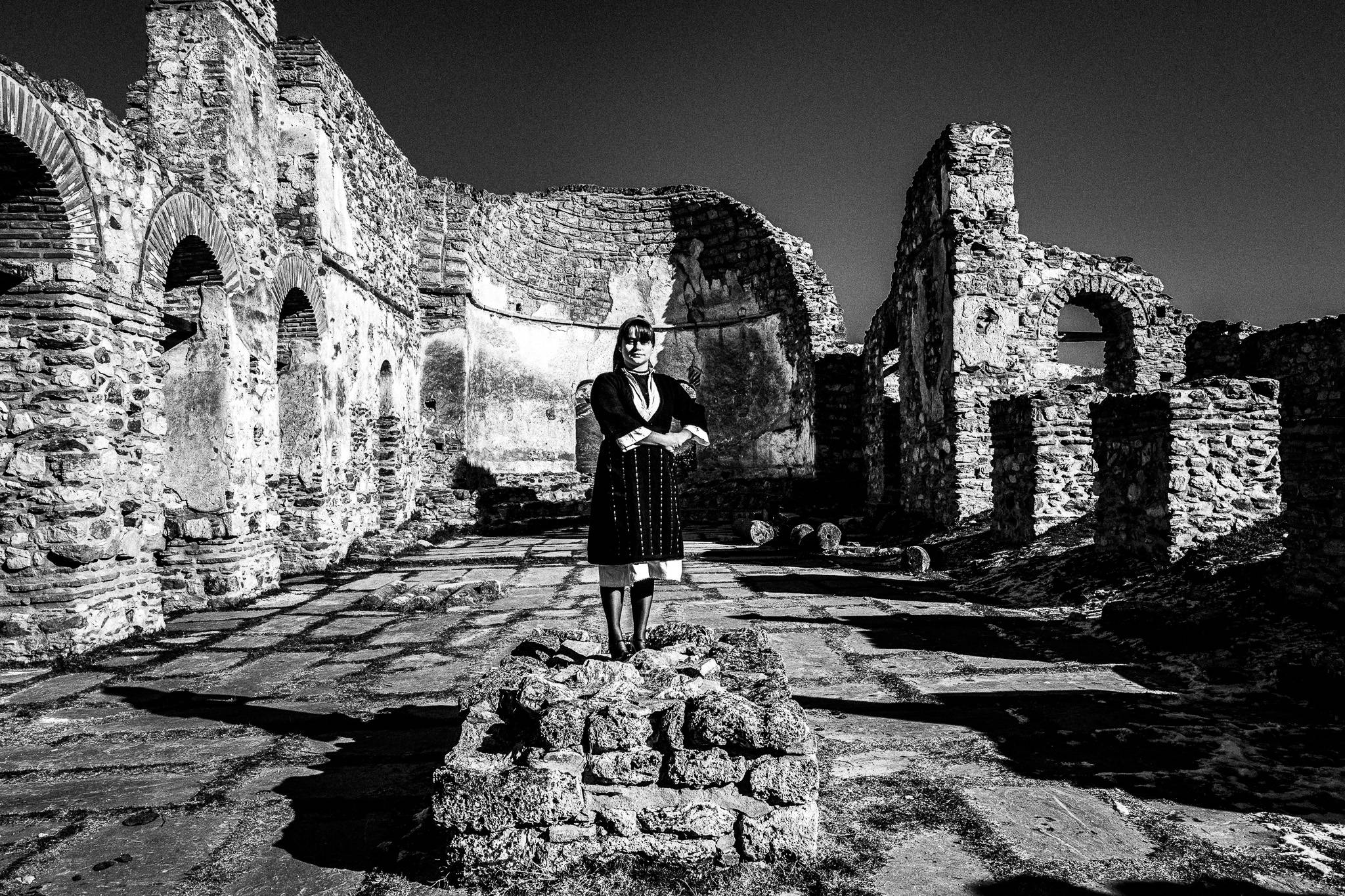 The traditional female costume at the Cathedral ruins, on the islet of St Achillios, Pagan Christmas customs of Northern Greece, by photographer George Tatakis