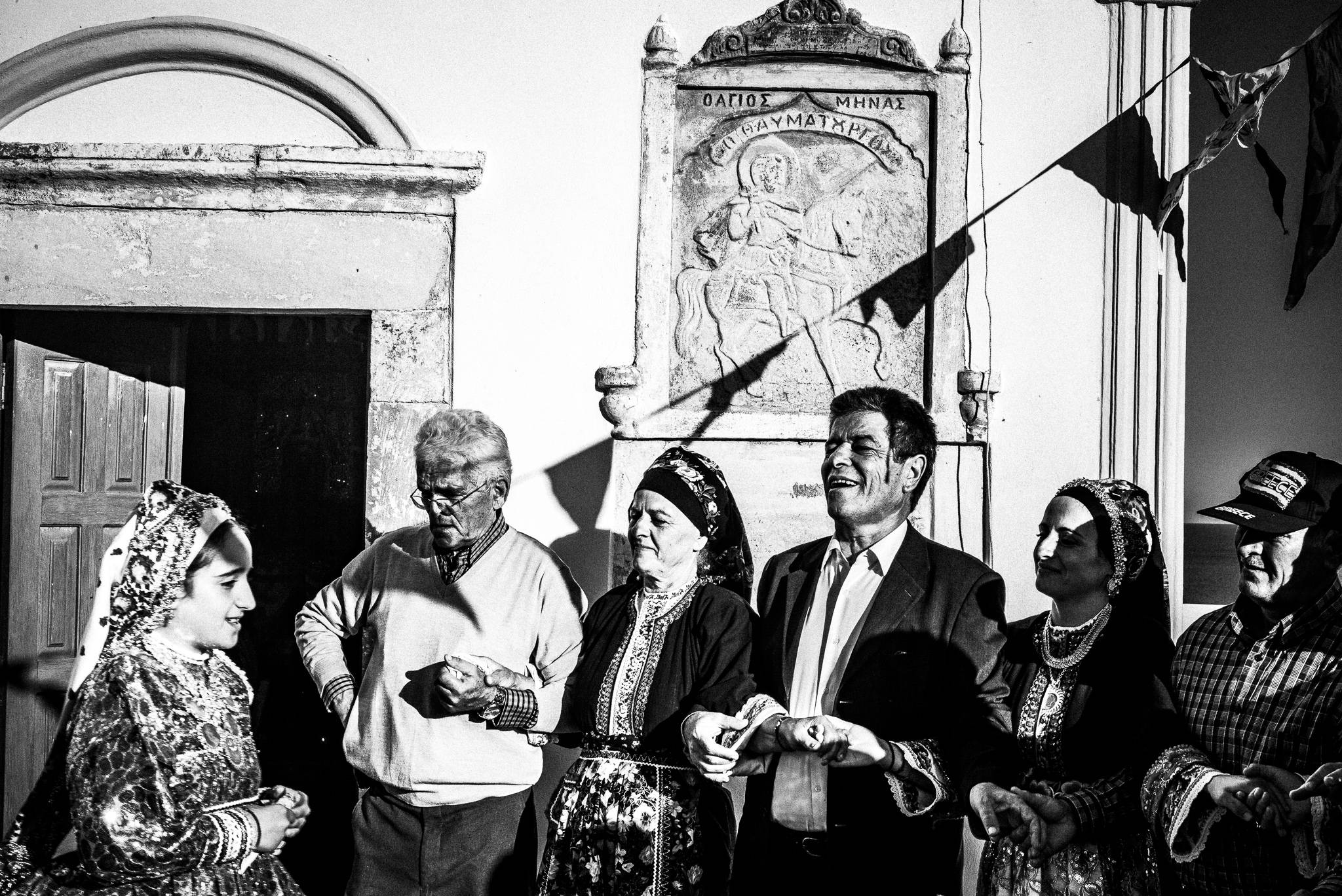 Dancing the pano choros in the church courtyard after the morning liturgy. St. Minas, Olympos, Karpathos, Greece. Black and white photography by George Tatakis