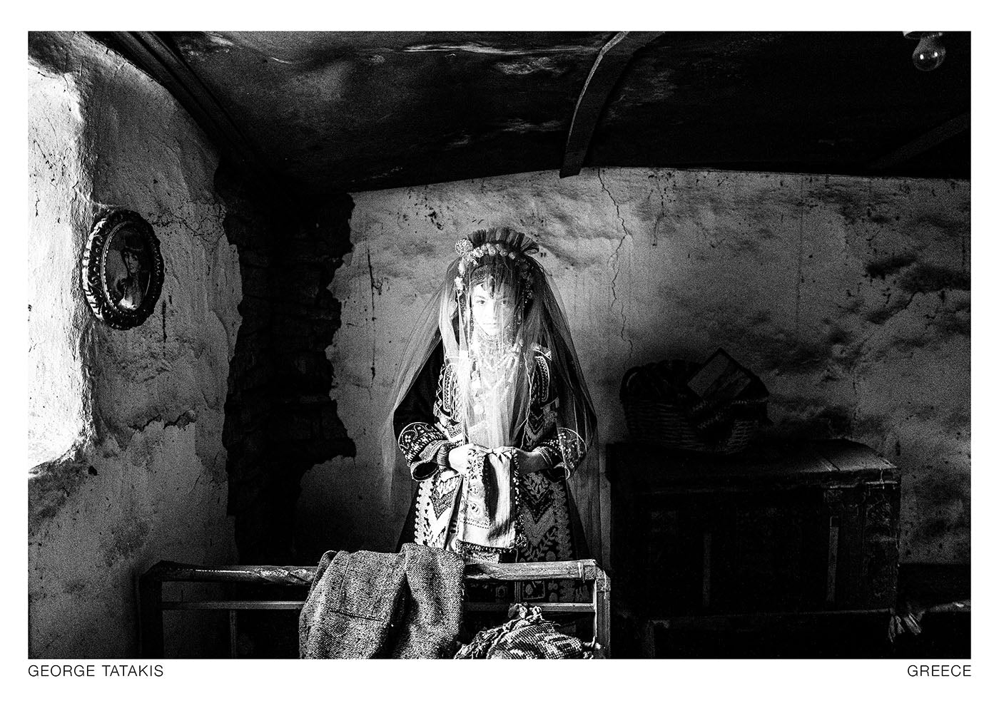 A veiled bride inside an abandoned house in the village of Issaakion, Evros, Thrace, Greece. Black and white photography postcard by George Tatakis, project Caryatis.
