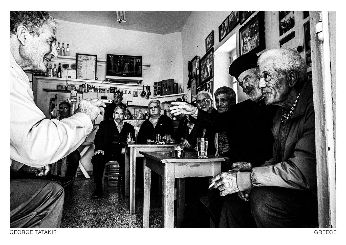 A group of men inside a small café in Olympos, Karpathos, Dodecanese, Greece. Black and white photography postcard by George Tatakis, project Ethos.