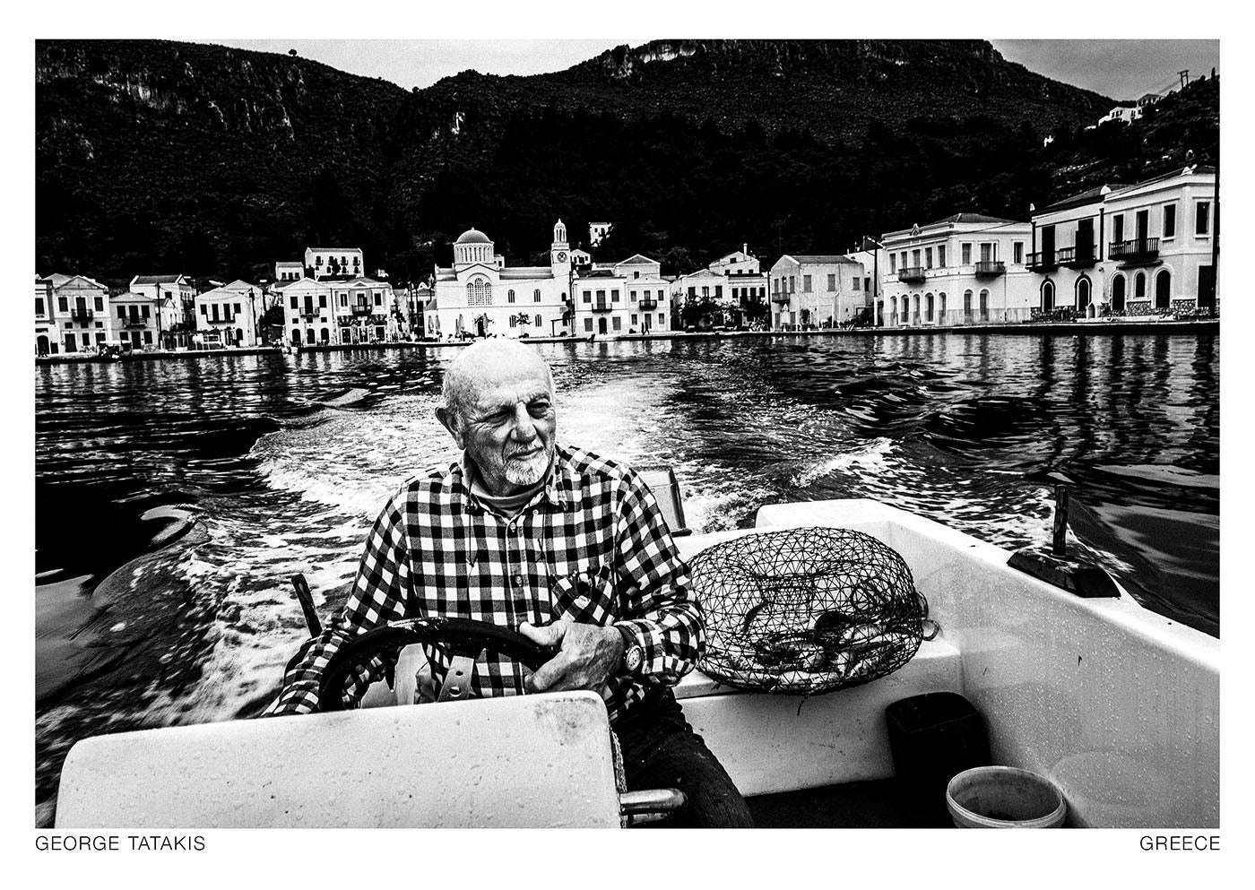 A local steering his fishing boat on the island of Kastellorizon, Dodecanese, Greece. The Easternmost island of Greece. Black and white photography postcard by George Tatakis, project Ethos.